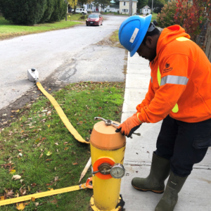 Image of Dele performing water hydrant maintenance and flushing.