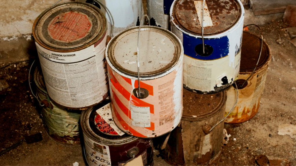 A stack of rusted and empty paint cans ready to go to the hazardous waste drop off event.
