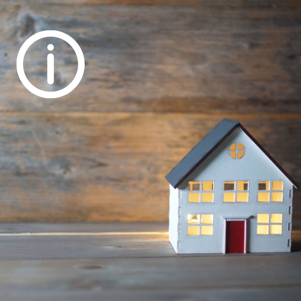 Little white house in front of wood background with information icon in top left corner